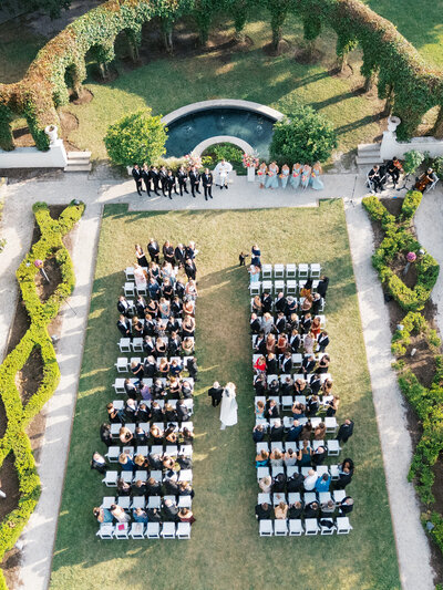 Aerial view of bride and dad walking down the aisle in Crane Cottage's sunken garden