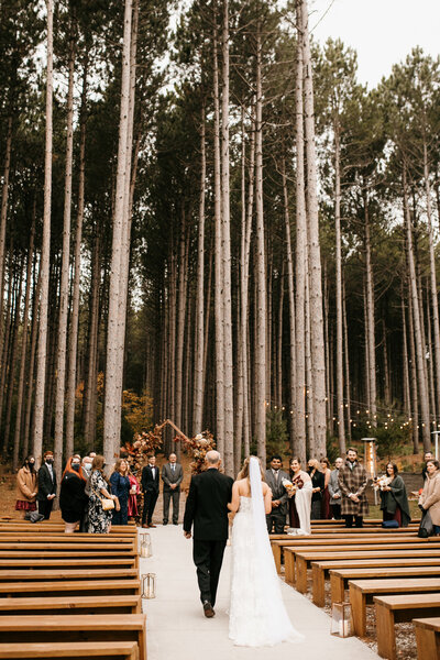 bride and groom exchanging vows in pine trees