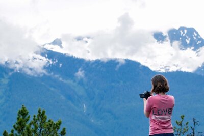 Image of woman in front of mountain with camera