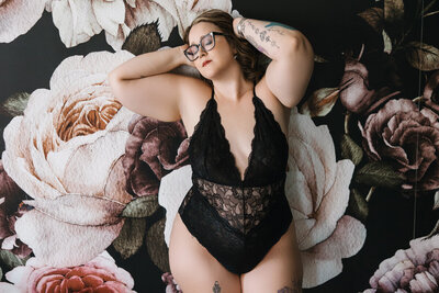 woman laying on green sheets with tattoos and orange hair