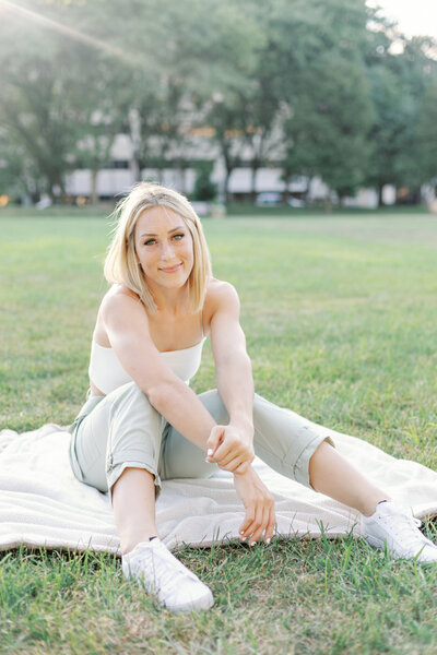 Photo taken by Monette Wagner Photography of high school senior girl sitting on white blanket on grass in Indianapolis