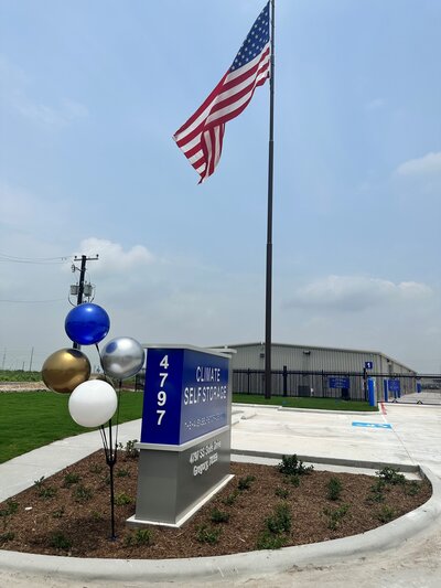 Entrance of The Haven Self Storage in Gregory Texas featuring the facility sign and American flag, representing the clean and accessible commercial property managed by WLS Interests.