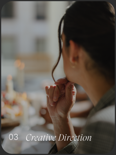 The profile of a dark haired woman looking over a beautiful tablescape. 