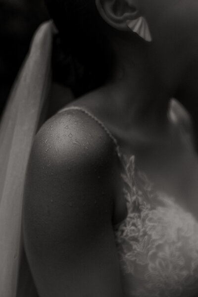 close up of raindrops on brides shoulder on rainy wedding day