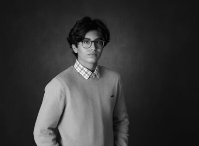 Black and white portrait of teenage boy wearing glasses and a sweater