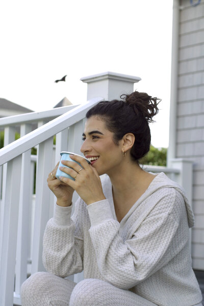 Jessie drinking tea on back porch in loungewear set