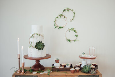 A wedding cake with green decorations captured by Devon Wedding Photographer