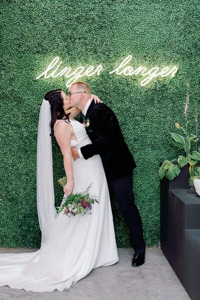 Flores & Pine wedding with a jewel-toned colour palette of emerald, violet and magenta, featuring emerald green loveseat from Stef Forward Events.