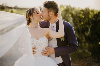 Coppia di sposi si bacia e si abbraccia tra le vigne del Casello il Palagio.