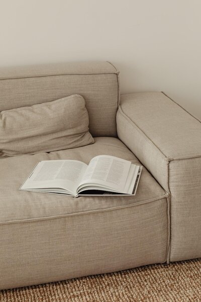 Aufgeschlagenes Buch auf einem beigen Sofa