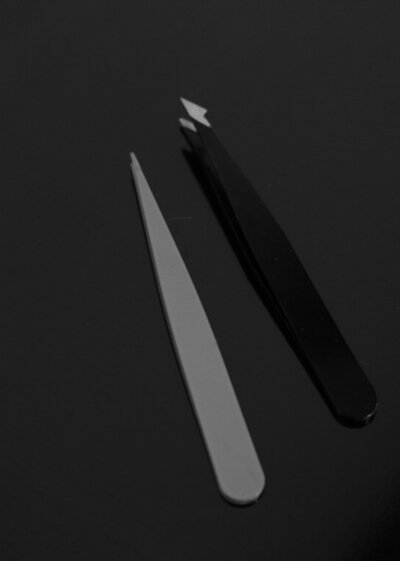 Two pairs of tweezers next to eachother in Black and White