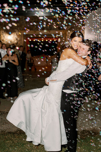 Groom hugging bride for their exit photos