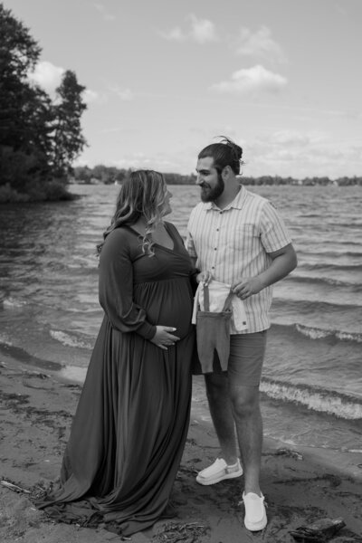 mother and father holding onesie at lake delta rome