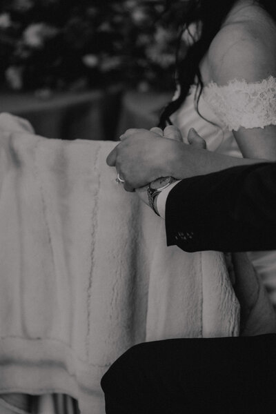 close up of couple holding hands at their wedding