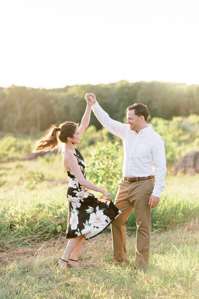 A couple at their summer sunset engagement with greenery and trees