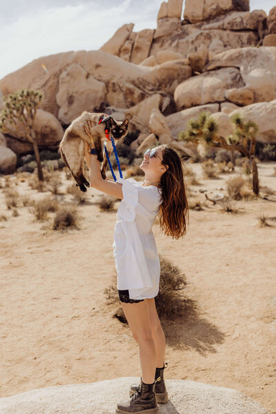 fun portrait photography at joshua tree california girl holding her siamese cat