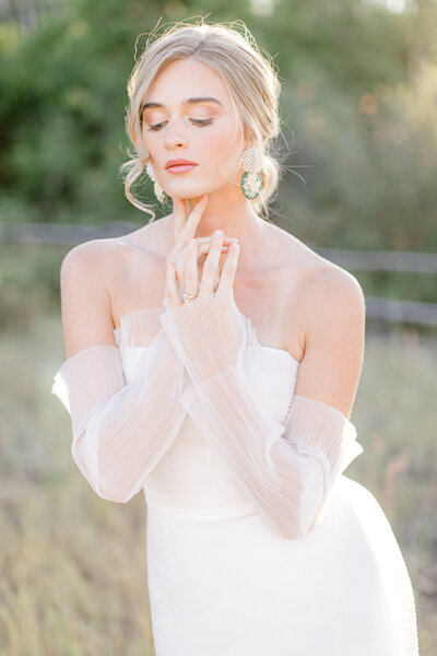 Bride in strapless gown with hands on face
