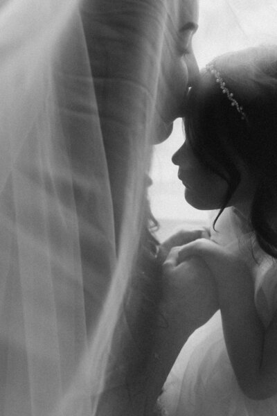 Mother and Daughter Bridal moment before the Elopement. Mum and Daughter under the veil and mum kissing her daughter on the forehead.  By Elk and Fir