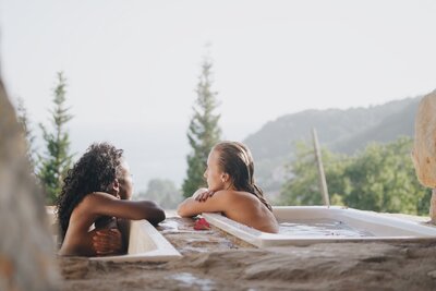 two girls in a hilltop bath while on a yoga retreat
