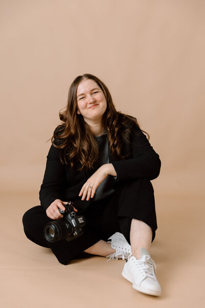 Desiree sitting and holding her camera.