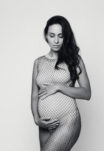 Portrait of a pregnant woman wearing a diamond net dress.