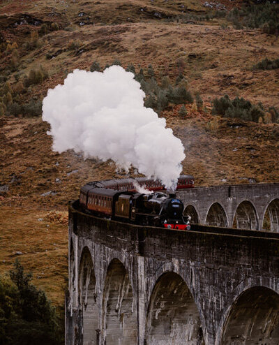 Le Jacobite Steam Train traversant le viaduc de Glenfinnan dans les Highlands en Écosse – une scène magique digne de Harry Potter, entre brume et nature sauvage
