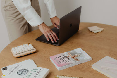 A women typing on a lap top. 