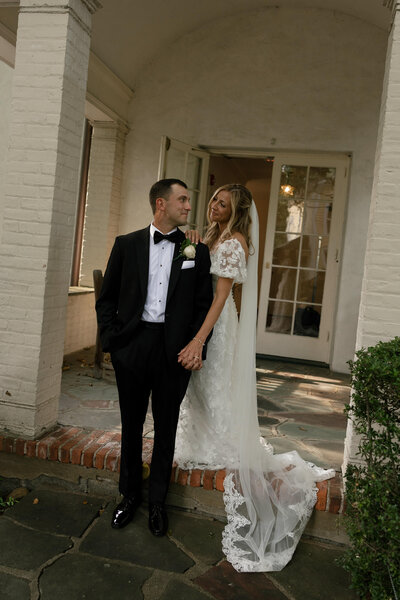 catholic wedding couple kissing while leaning against a limo