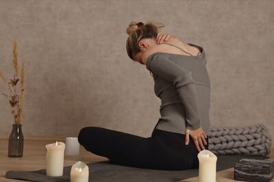 A woman holds her neck and back from hypermobility-related pain
