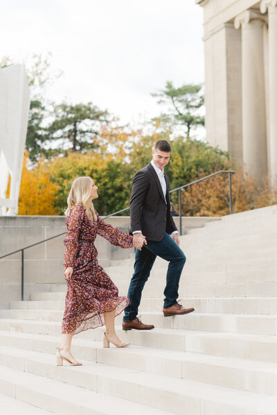 engaged couple walking up the stairs of the Nelson-Atkins Museum during engagement session