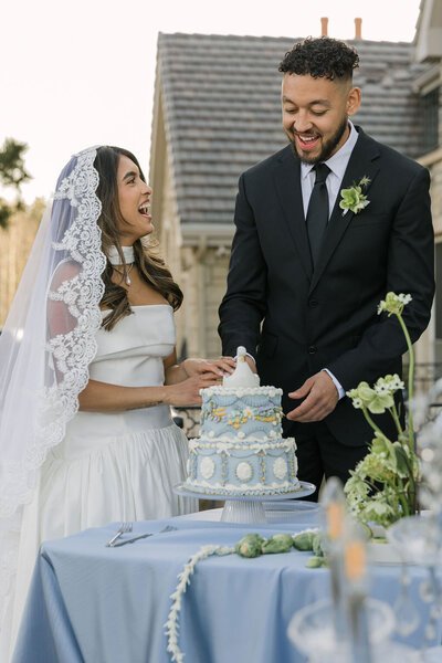 Candid, vintage wedding cake cutting outdoors at Greystone Castle Boulder