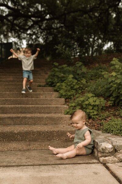 Two little brothers playing on outdoor stairs