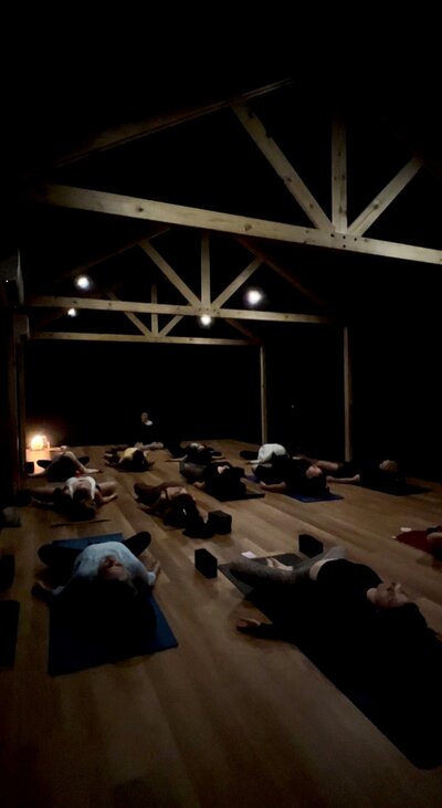Restorative yoga class in dark yoga studio