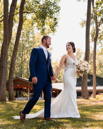 The bride and groom holding hands during their Spring Lake Winery wedding.