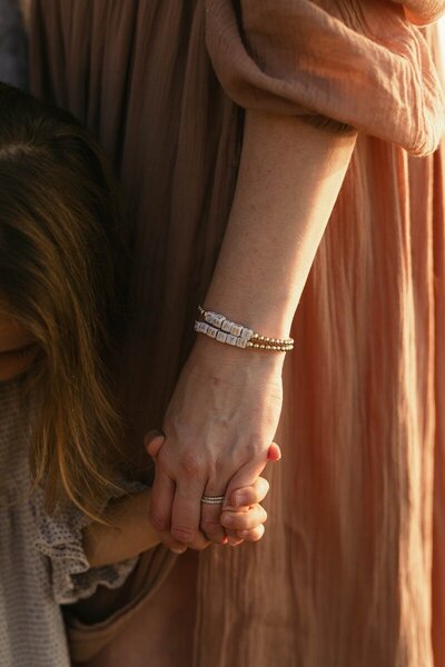 Close-up of holding hands during maternity session by photographers in Traverse City Michigan

