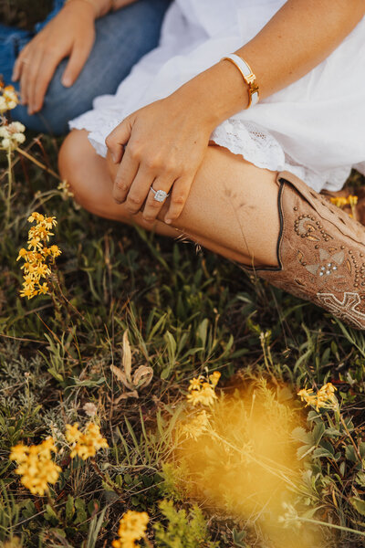 Detail shot of bride and groom’s legs in a field of yellow flowers during a spring wedding in Montana.