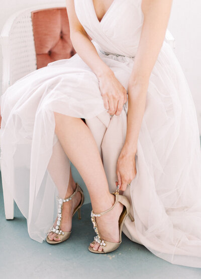bride getting ready while sitting on chair photographed by calgary wedding photographers David and Breanne