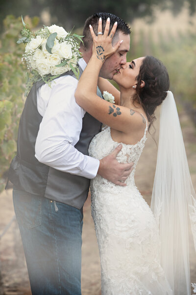 a soft romantic photo of bride and groom kissing