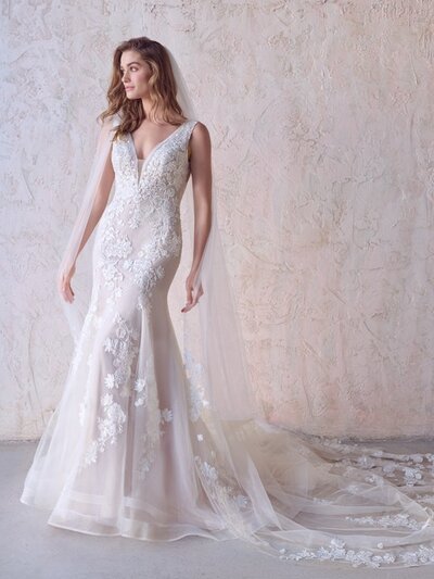 Boho A-Line Wedding Dress.  Looking to show off your shoulders and collarbones? This boho A-line wedding dress features a plunging V-neckline and lacy straps to help you do just that.