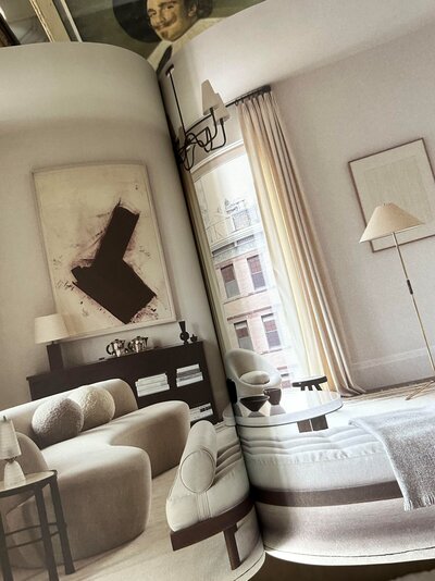 An open book displaying a two-page spread from Interiors by Alyssa Kapito, showcasing refined design and timeless elegance.