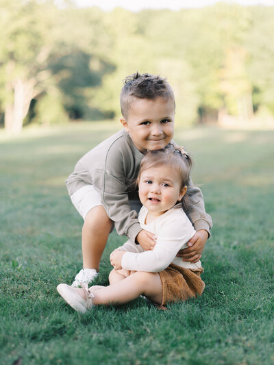 family sitting in the tall grass at a beach having fun