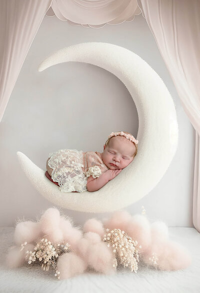 Newborn baby wrapped in pink sleeping with a pink headband