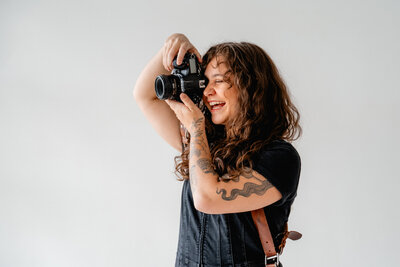 woman holding camera smiling