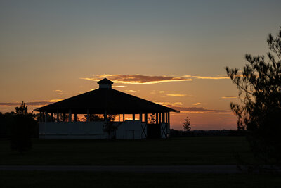 An automatic horse walker silhouetted at sunrise.