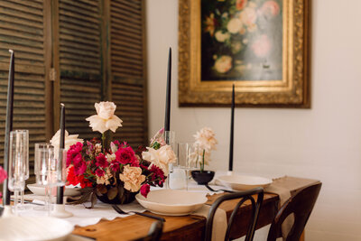 Elegant wedding reception table setup featuring posh black, dark pink, and white floral arrangements before guests arrive at an intimate backyard wedding in Richmond, Virginia.