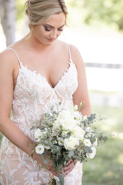 Bride looking down at her bouquet on wedding day