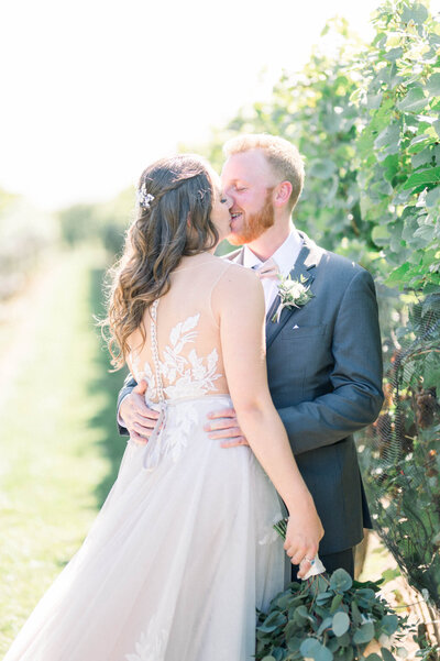 Bride and groom kissing in a Vineyard captured by Niagara wedding photographer