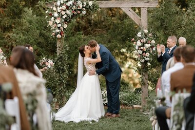 Romantic Southern Wedding vibes on Ceremony arbor and bride and groom kissing