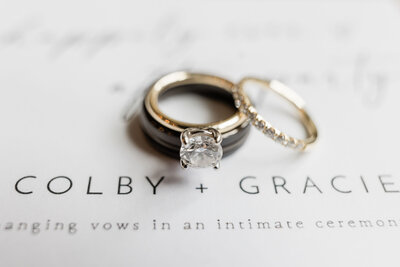 Close-up of wedding rings, including a diamond engagement ring, displayed on custom wedding stationery during a Savannah elopement.