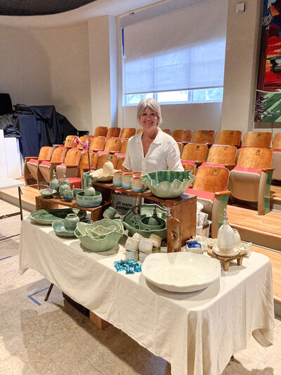 Jill stands beside a table of her pottery on display at the Studios of Key West in Key West, FL during a monthly art walk featuring more than 25 local businesses and artists in the White Street Gallery District